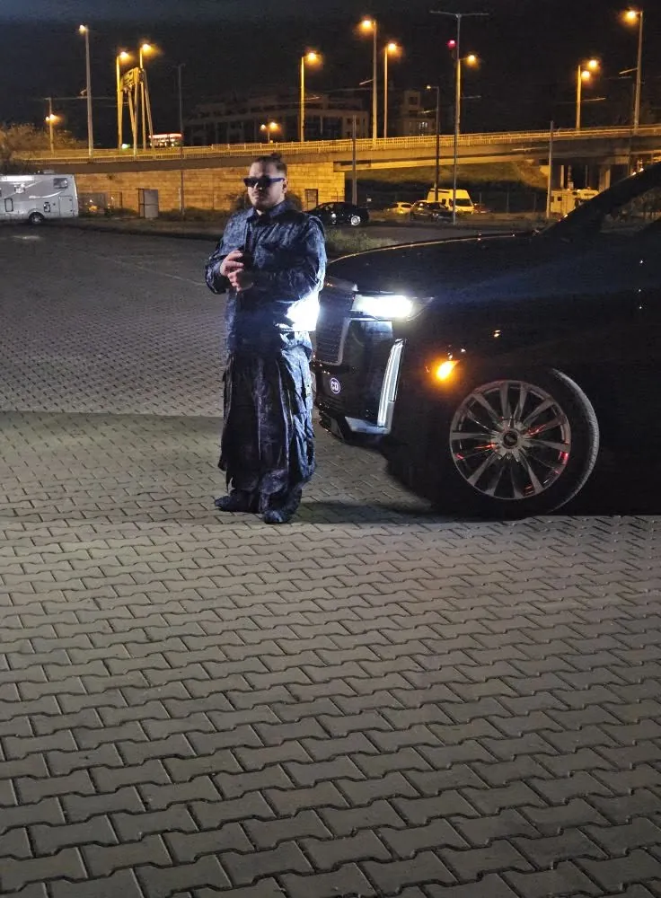Egyenruhás alak egy fekete terepjáró mellett éjszaka